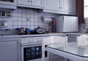 a kitchen with white cabinets and a stove top oven at Vasiliki's House in Naxos Chora