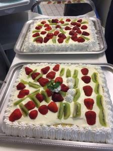 two trays of strawberries and kiwis on top of a cake at Hotel Grifone in Principina a Mare