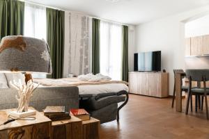 Maison Poluc hotel apartments في تشامبولوك: غرفة معيشة مع سرير وأريكة وطاولة