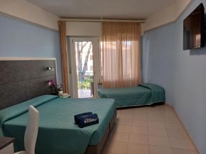 Habitación de hotel con 2 camas y ventana en Hotel Monna Lisa, en Procchio