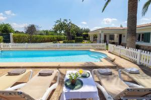 a swimming pool with two chairs and a table and a house at Ideal house for two families with pool and barbecue in Palmanyola