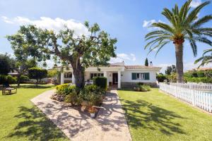 a house with a white fence and palm trees at Ideal house for two families with pool and barbecue in Palmanyola +33 photos
