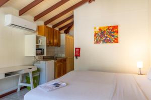 a small room with a bed and a kitchen at Talk of the Town Inn & Suites - St Eustatius in Oranjestad