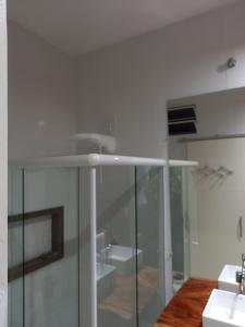 Baño blanco con lavabo y espejo en Suítes Mathias flat en Conservatória