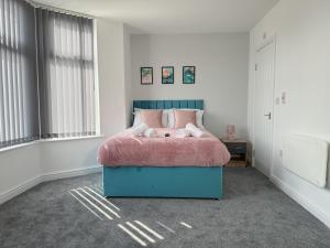 a bedroom with a bed with a pink blanket at Relax @ Southfield in Middlesbrough