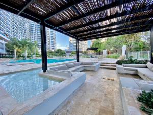 an outdoor patio with a pool and a wooden pergola at Reserva del Mar in Puerto de Gaira