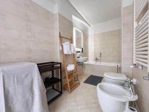 e bagno con servizi igienici, vasca e lavandino. di Maison Poluc hotel apartments a Champoluc