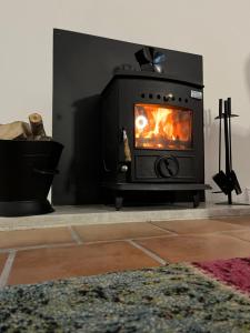 a stove in a living room with a fireplace at Sweet Lamb Farmhouse in New Ross