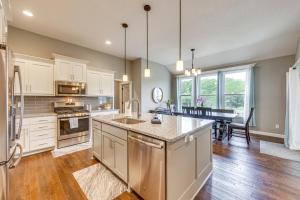 a large kitchen with white cabinets and a kitchen island at Platte City Retreat with Patio, Near Kansas City! in Platte City