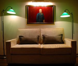 a couch in a room with two lamps and a painting at Hotel Mitra, Story Hotels in Ptuj