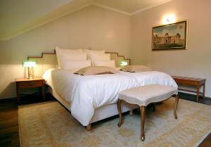 a bedroom with a large white bed with two tables at Hotel Mitra, Story Hotels in Ptuj