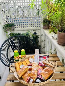Chambre d hôte - Bambou في سان مور دي فوس: سلة من الخبز والمشروبات على طاولة على شرفة