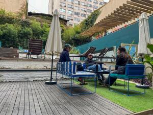 Viajero Buenos Aires Hostel في بوينس آيرس: مجموعة من الناس يجلسون على الكراسي في الفناء