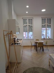 eine Küche und ein Esszimmer mit einem Tisch und Stühlen in der Unterkunft Stafétaház Apartmanok in Vác