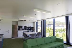 UBC Okanagan Campus في كيلونا: غرفة معيشة مع أريكة خضراء وطاولة