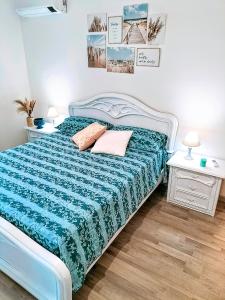 una camera con un letto blu con due cuscini sopra di Anzio Paradise ad Anzio