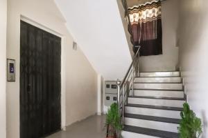a hallway with stairs with a black door and a black door at OYO SHRIDHAR CREATIVE Hotel & Restaurant in Nagpur