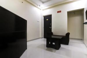 a room with a black chair and a mirror at OYO SHRIDHAR CREATIVE Hotel & Restaurant in Nagpur