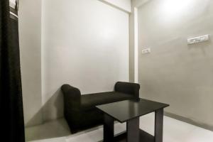 a black chair and a table in a room at OYO SHRIDHAR CREATIVE Hotel & Restaurant in Nagpur
