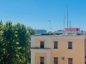 un edificio bianco con un’antenna sopra di B&b Comfort Home Apartment a Civitavecchia Altre 5 foto