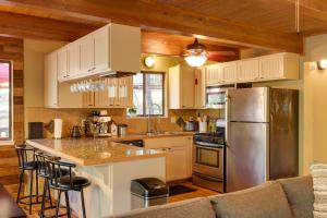 a kitchen with white cabinets and a stainless steel refrigerator at Spacious Groveland Cabin with Wraparound Deck! in Groveland