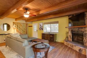 a living room with a couch and a fireplace at Spacious Groveland Cabin with Wraparound Deck! in Groveland