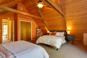 - 2 lits dans une chambre dotée de plafonds en bois dans l'établissement Spacious Groveland Cabin with Wraparound Deck!, à Groveland