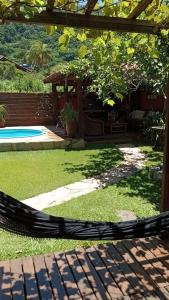 een hangmat in een tuin met een zwembad bij Solar Lisboa 100 m da Praia com vista para mar in Balneário Camboriú