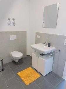 une salle de bain avec un lavabo et des toilettes dans l'établissement FeWo für 7 Personen/Netflix/Parking/WLAN/stilvoll, à Pöttmes
