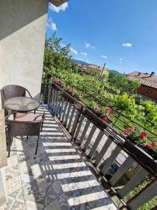 a balcony with a chair and a garden of flowers at Sobe Lejla in Vipava