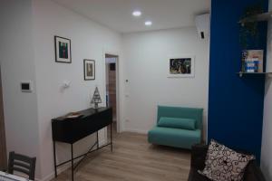 a living room with a blue chair and a desk at Appartamento Casa Del Fabbro in Sovizzo