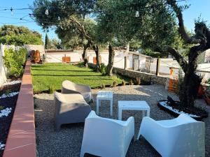 a group of white chairs and tables in a yard at Acquamarina in Gaeta