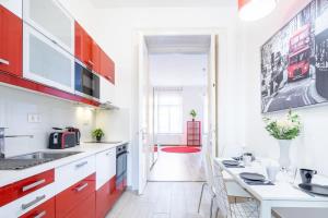 a kitchen with red cabinets and a dining area at Super central convenient apartment in Budapest