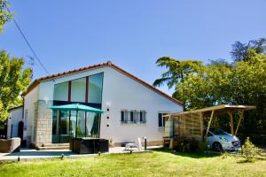 a house with a car parked in front of it at Maison Cosy : Pétanque, Baby-foot & Ping-Pong ! in Labarthe-sur-Lèze