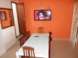 Hostel Tavares Bastos في ريو دي جانيرو: غرفة طعام مع طاولة وتلفزيون على الحائط