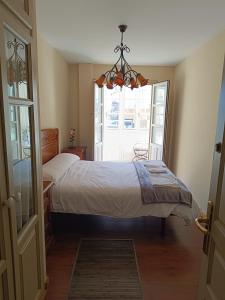 a bedroom with a bed and a chandelier at El espolon in Comillas +4 photos