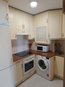 a kitchen with a washing machine and a microwave at El espolon in Comillas