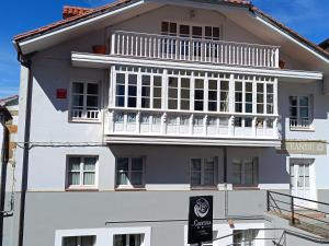 a white building with a balcony on top of it at El espolon in Comillas