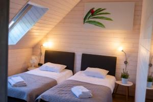 2 Betten in einem Zimmer mit Dachgeschoss in der Unterkunft Sõru Puhkemaja in Sõru