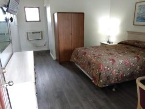 a hotel room with a bed and a cabinet at Eldorado Motel, New Castle in New Castle