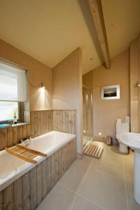 uma grande casa de banho com banheira e lavatório em Ness Castle Lodges em Inverness