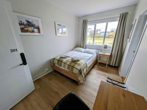 a small bedroom with a bed and a table at The Stykkishólmur Inn in Stykkishólmur