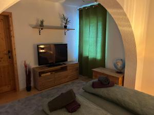 Ferienwohnung Mariana في باد ايشل: غرفة معيشة مع تلفزيون وستارة خضراء