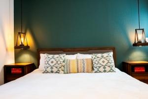 箭头湖The Mighty Pines Retreat + Large Patio + BBQ+View!的卧室配有一张床,墙上挂着两盏灯