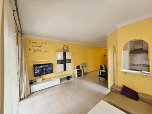 uma sala de estar com uma parede amarela em Away but Home em San Miguel de Abona