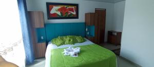 内瓦Hotel Bella Orquidea的卧室里有一张床,床铺是绿色的