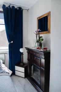 Schlafzimmer mit einem Tisch, einem Kamin und einem Spiegel in der Unterkunft Welcome in Ostróda