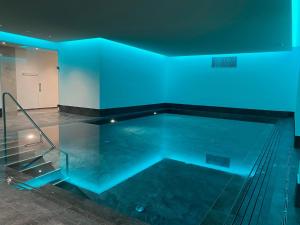 a swimming pool with blue lights in a room at Hotel Helvetia in Müstair
