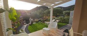 a patio with white chairs and a view of a garden at Chia Sweet Home in Chia
