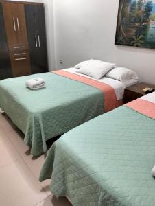 two beds sitting next to each other in a bedroom at 203 RV Apartments Iquitos-Apartamento con dos habitaciones in Iquitos